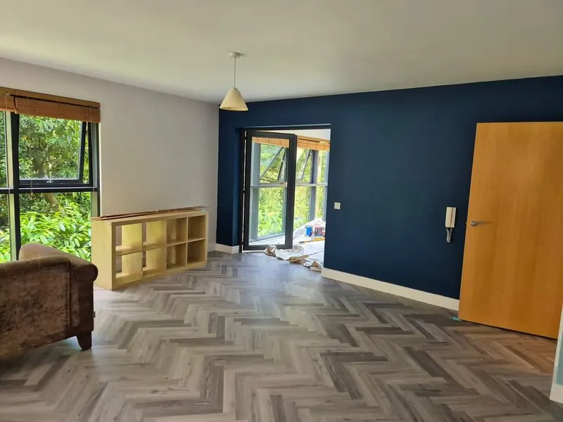 Navy feature wall and repainted alcove shelving in a living room