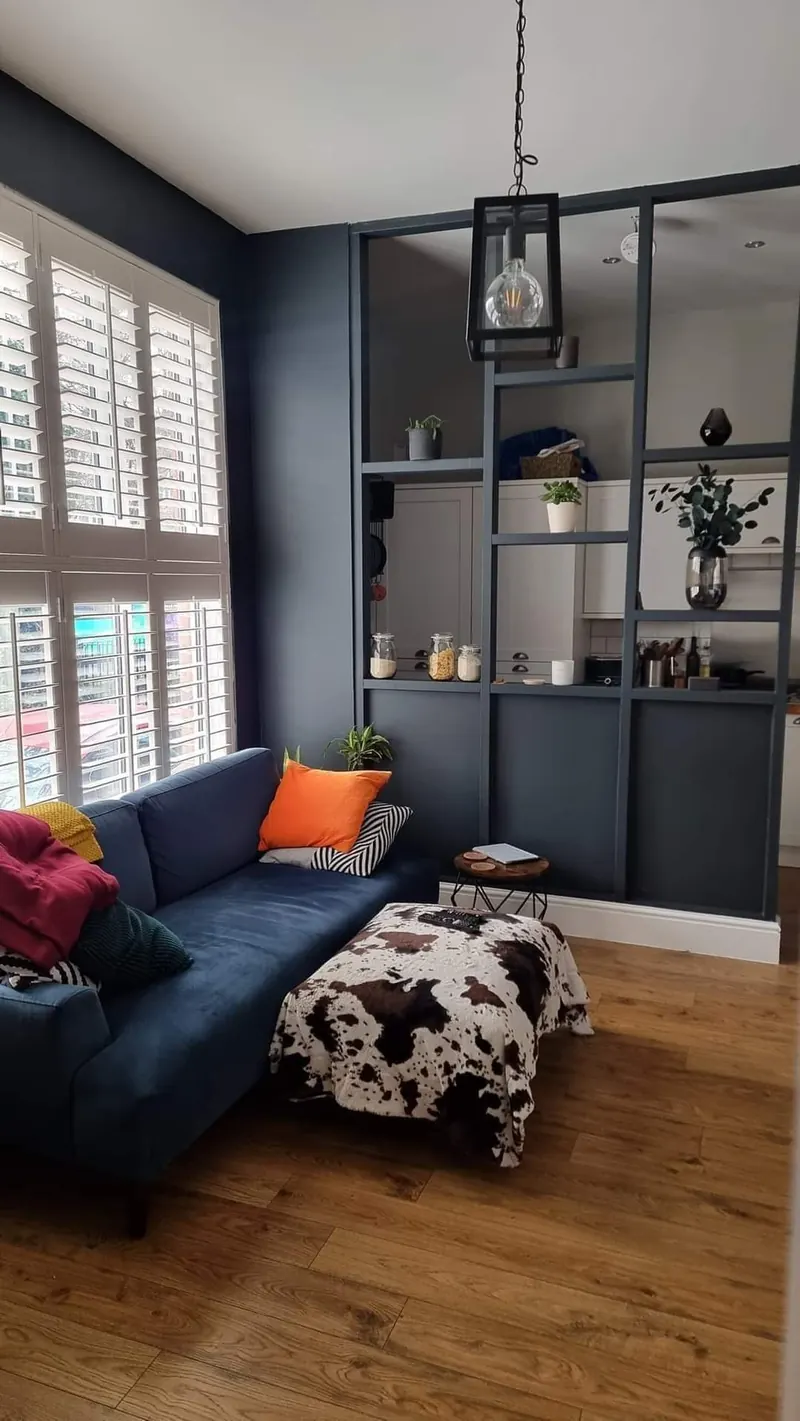 Living room finished in deep navy with original floorboards